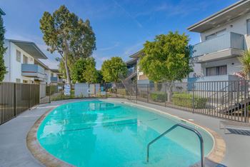 A swimming pool in front of an apartment building with a pool